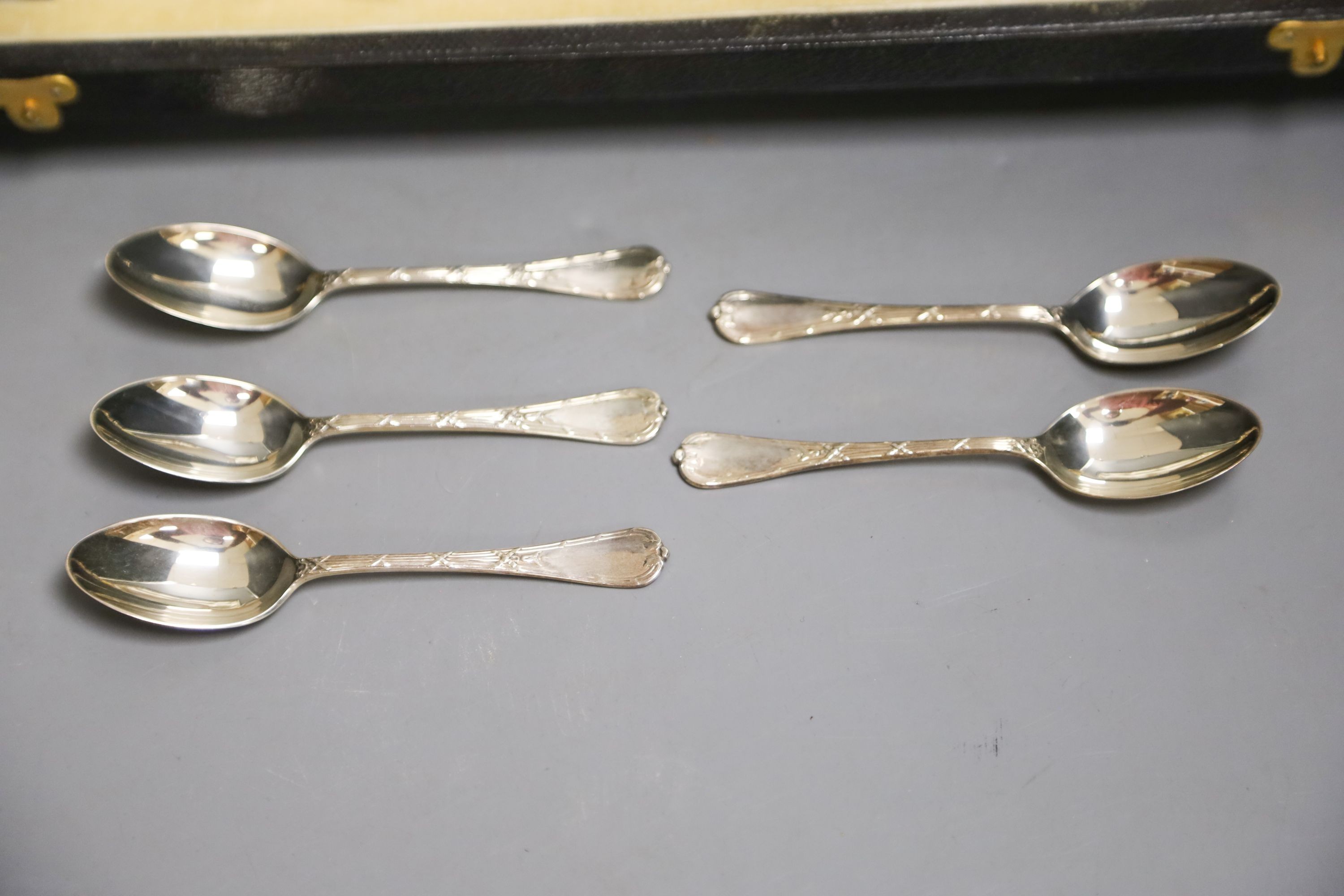 A set of six Aynsley coffee cans and saucers, with silver holders and a set of six silver spoons